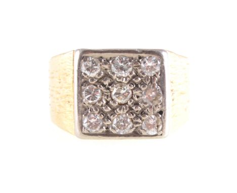 A gentleman's diamond set signet ring, nine brilliant cut diamonds pave set in a yellow and white metal signet mount with 12.