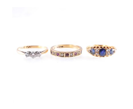 Three gemset rings, a diamond three stone ring, the graduated brilliant cut stones claw set in a traditional mount stamped 18