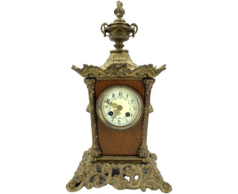 French - early 20th century 8-day mantle clock of tapering form on a cast brass base with scroll work and splayed feet, surmo