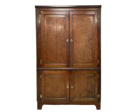 Large George III oak corner cupboard, enclosed by four panelled cupboards, painted interior fitted with shelves, on bracket f
