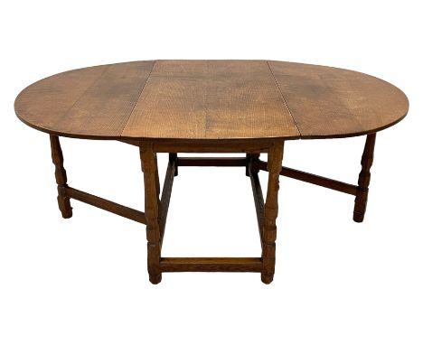 Mouseman - oak dining table, oval drop-leaf top, on octagonal supports united by stretchers, gate-leg action base, carved wit