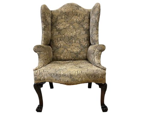 George III mahogany framed fireside wingback armchair, high shaped back over rolled arms and sprung seat, upholstered in anti