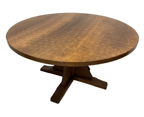 Mouseman - oak dining table, adzed figured circular top, raised on cruciform base, the supports and sledge feet also adzed, c