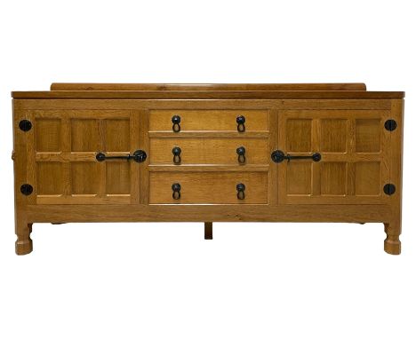 Mouseman - oak 6' sideboard, raised back over adzed top, fitted with three central drawers and flanking cupboards, enclosed b