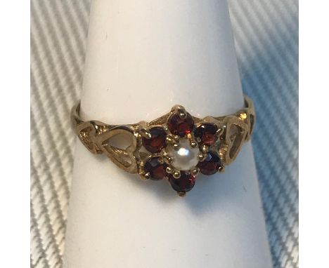 A 9ct gold garnet and single pearl ladies ring, designed with heart shaped sides. Rings size O. Weighs 1.40grams. 