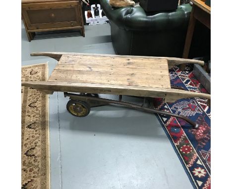 An unusual antique rustic style coffee table made from an antique wooden market cart top, fitted with a vintage Willmot Truck