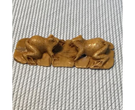 A Japanese meiji period netsuke detailing two frogs facing each other. Signed to the base. Measures 4.5cm in length. 