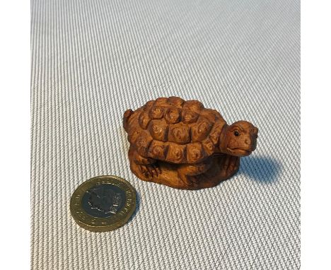 A Small Japanese hand carved tortoise netsuke figure. Signed to the base, Measures 5.3cm in length. 