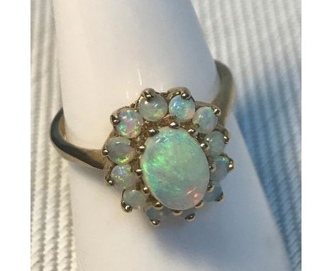 A Beautiful Ladies 9ct gold opal cluster set ring with large single opal stone. Ring size N1/2. Weighs 2.83grams 