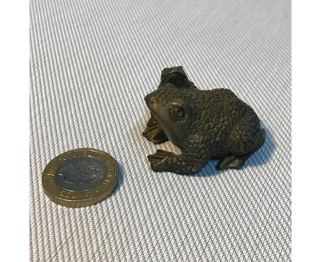A Japanese hand carved netsuke figure of two frogs. Signed to base by the artist. Measures 3.7cm in length. 