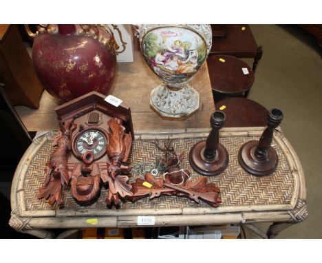 A German cuckoo clock and a pair of wooden candlesticks