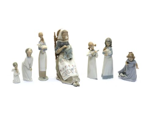 A collection of seven Nao and Lladro figurines,late 20th century, the largest example modelled as a seated embroidering woman