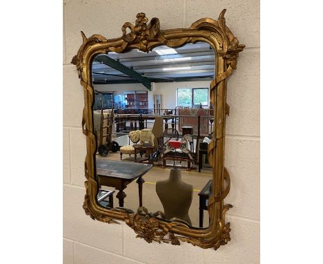 Vintage wall mirror of Regency style, the wood and plaster frame of entwined ribbons and flowers, gilt finish, approximately 