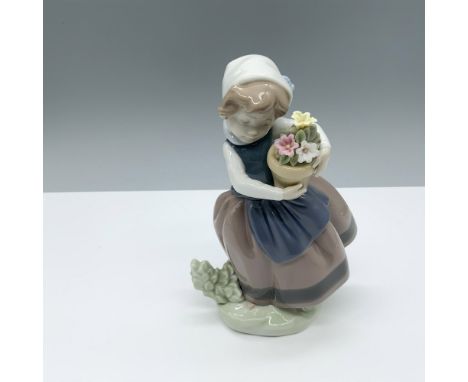 Glossy figure of a young woman holding potted flowers. Lladro backstamp. This item has its original box (4.75"L x 4.5"W x 8"H