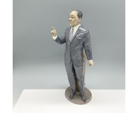 Glossy dignified figure of an esteemed man standing by a podium, ready to make a speech. Lladro backstamp. This item has its 