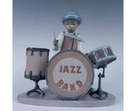 Glossy figure of a musician behind a kit playing his songs. Lladro backstamp. This item has its original box (9.25"L x 7.75"W