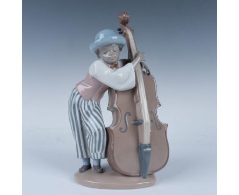 Glossy figure of a young man leaning across his instrument. Lladro backstamp. This item has its original box (7.5"L x 5.75"W 
