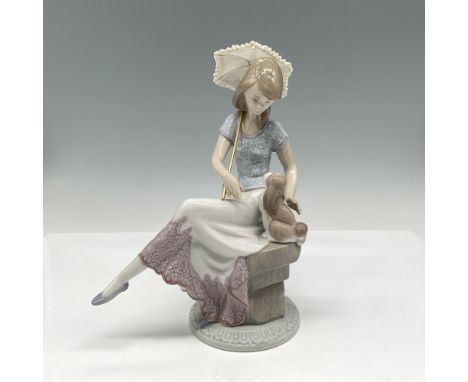 A glossy figure of a woman seated with her dog who is affectionately gazing at her. 5th Anniversary Lladro Collectors Society