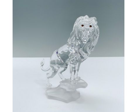 A majestic lion with a flowing mane stands at the edge of a rock, unleashing a powerful roar. Swarovski backstamp. This item 