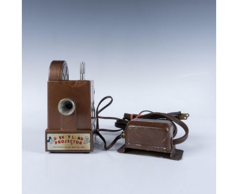 A vintage crank-feed toy projector powered by electrical elements. Includes 2 color films; Pinocchio, and Goofy The Sportsman