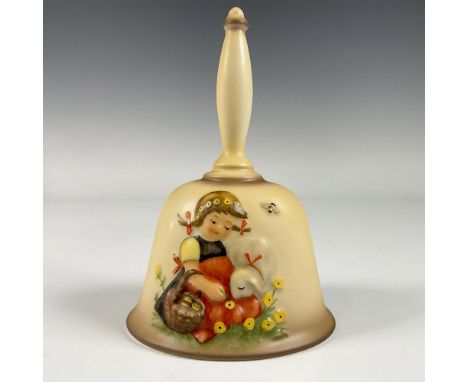 A hand bell decorated with a bas-relief of a young girl sitting with her lamb as she collects yellow flowers. 14th Edition An