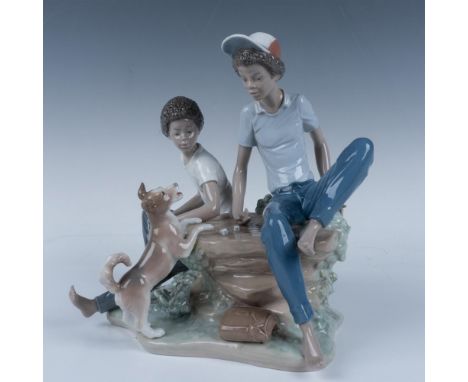 Glossy charming figure of two young boys playing a dice game, hanging around with their dog. Lladro backstamp. This item has 