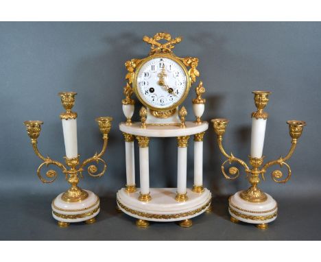 A French white marble and gilt metal mounted clock garniture, the clock with enamel dial with two train movement flanked by a