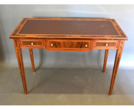 A French style writing desk, the leather inset top above three drawers with lion mask handles raised upon square tapering leg