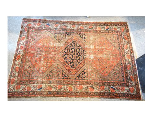 A North West Persian woollen rug with a central medallion within an all over design upon a red, blue and cream ground within 