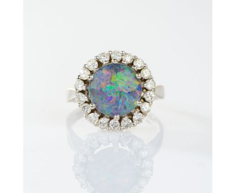 Opal-Brillant Ring. 14 kt. WG, gest. MM: K. Im Zentrum der  runde Opal (Triplette Dm. ca. 10 mm) mit 18 Brill. zus. ca. 0,70 
