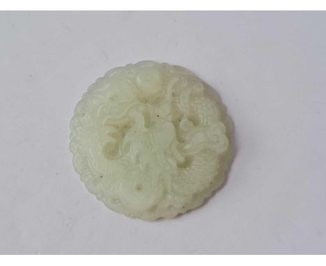 A decorative jade circular pendant depicting dragon after a pearl       24 gms