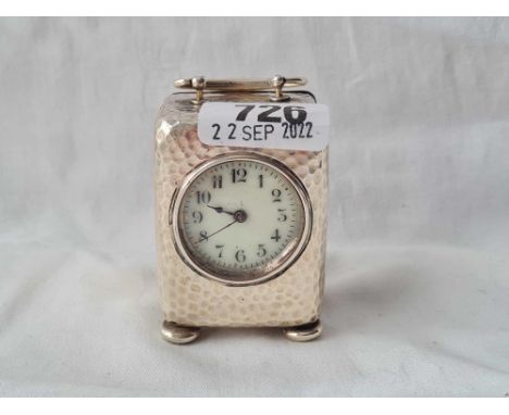 A silver cased travelling clock with hammered finish and French Brass movement, 3" over handle, Chester 1897