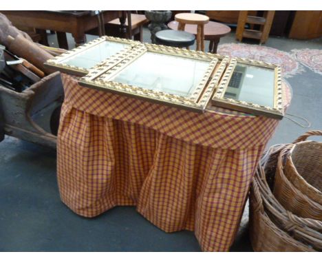 A kidney shaped dressing table with chequered cover, with gilt framed triple mirror