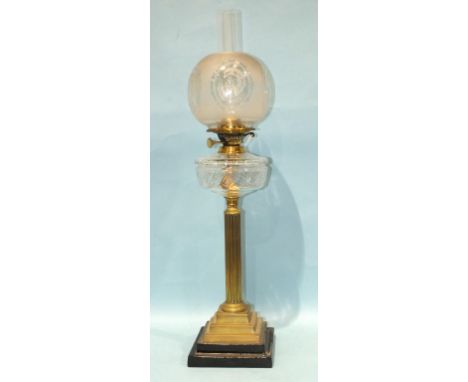 A Victorian brass column oil lamp with cut glass reservoir and later shade, 82cm high (including chimney).