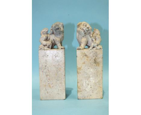 A pair of Chinese carved stone seals, each surmounted by a qilin and young, with characters, inscription and seal beneath, 18