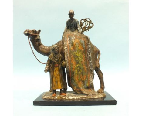 A spelter lighter in the form of an Arab seated on a camel and another standing holding a carpet, on rectangular base, 19.5cm