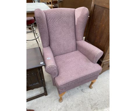A VINTAGE WING BACK ARMCHAIR 