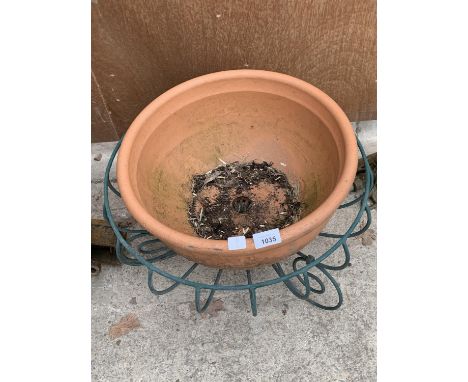 A LARGE TERRACOTTA POT AND A PLASTIC COVERED METAL PLANTER 