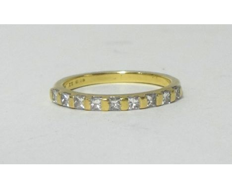 An 18ct half band eternity ring set with princess cut diamonds, size K.