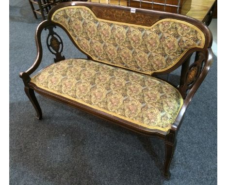 An Edwardian line inlaid mahogany settee with marquetry inlaid back rail over two carved side panels on slender legs upholste