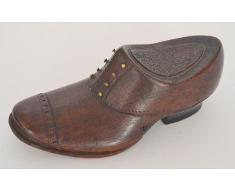 A turned wooden snuff box modelled as a shoe with brass rivet eye holes, length 11cm. 