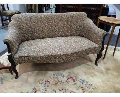 An early 20th Century settee of serpentine outline, on cabriole legs upholstered in floral tapestry, width 145cm