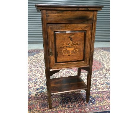 A Victorian inlaid rosewood music cabinet the interior enclosed by a door decorated with an urn and swags above a shelf, widt