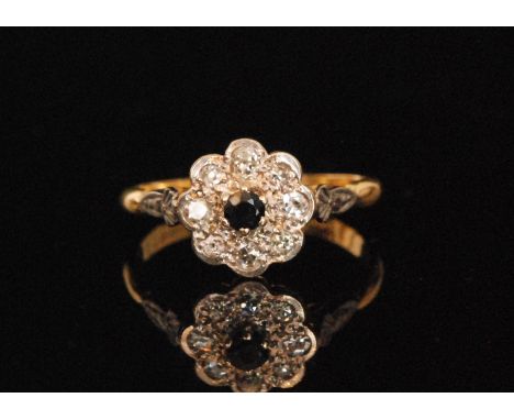 A mid 20th Century sapphire and diamond daisy cluster ring, central sapphire within a eight stone diamond surround, ring size