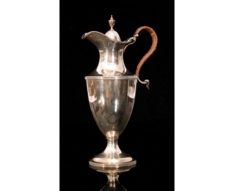 A hallmarked silver claret jug of plain baluster form terminating in raffia arched scroll handle and urn finial, weight 15.5o