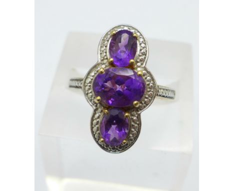 A silver and three stone amethyst dress ring, R 