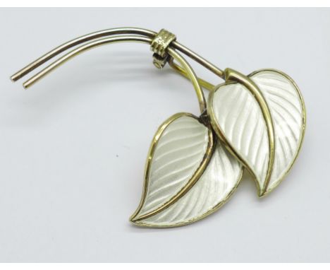 A Norwegian silver gilt and white enamel leaf brooch 