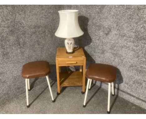 An oak lamp table, two metal stools and a table lamp