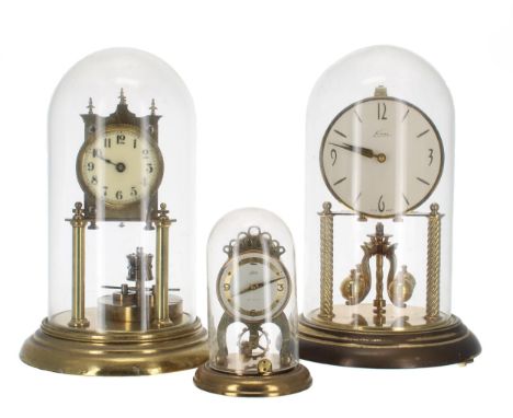 German torsion brass mantel clock, the 2.75" cream dial and movement upon cylindrical supports over a disc pendulum, under a 