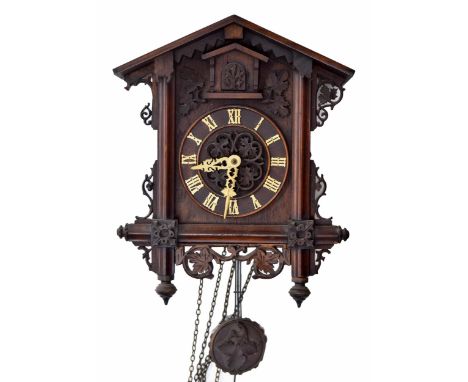 Black Forest two train cuckoo clock, the 5.5" dial within a chalet style case with applied and pierced foliate carvings, 15" 